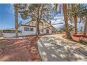 Charming two-story home surrounded by palm trees, desert landscaping, and a long driveway at 7079 Laredo St, Las Vegas, NV 89117