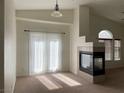 Cozy living room with a fireplace, arched windows, and a sliding glass door for natural light at 8680 Horizon Wind Ave # 101, Las Vegas, NV 89178