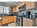 Modern kitchen featuring stainless steel appliances, tile backsplash, and granite countertops at 9051 Iron Cactus Ave, Las Vegas, NV 89148