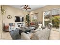 Comfortable living room featuring neutral walls, plush seating, ceiling fan, and sliding door to patio at 9172 Tudor Park Pl, Las Vegas, NV 89145