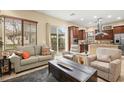 Open concept living area with kitchen access, comfortable seating, and natural light at 9172 Tudor Park Pl, Las Vegas, NV 89145