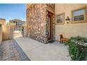Exterior showcasing stone accents, a gate, a bench, potted plants, and a brick walkway at 949 Via Stellato St, Henderson, NV 89011