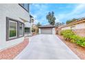 View of the property highlighting the spacious driveway leading to a detached garage at 10639 Isola Bella St, Las Vegas, NV 89141
