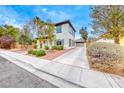 Charming two-story home with manicured landscaping and a driveway leading to the garage at 10639 Isola Bella St, Las Vegas, NV 89141