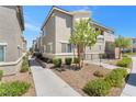 Exterior of a modern two-story townhome showcasing manicured landscaping and neutral stucco at 12367 Indigo Montage Rd # 3, Las Vegas, NV 89183