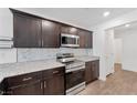 Beautiful kitchen featuring stainless steel appliances, granite countertops, and dark wood cabinetry at 12367 Indigo Montage Rd # 3, Las Vegas, NV 89183