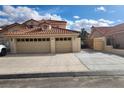 The property has a driveway leading up to a three-car garage, offering ample parking and storage space at 1255 Del Lilly Ln, Las Vegas, NV 89123