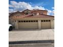 Spacious three-car garage with a large driveway, part of a well-maintained home exterior at 1255 Del Lilly Ln, Las Vegas, NV 89123
