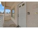 Second-story covered entryway featuring white door, window, and a wall-mounted lockbox outside unit #216 at 1900 N Torrey Pines Dr # 216, Las Vegas, NV 89108