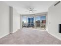 Modern living room featuring sleek tile floors, a ceiling fan, and a wall of windows offering scenic city views at 200 W Sahara Ave # 3004, Las Vegas, NV 89102