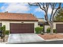 Charming single-story home featuring a brown garage door, stucco walls, and a red tile roof at 3053 Conquista Ct, Las Vegas, NV 89121