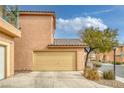 Exterior view of a two-story home featuring a two-car garage and neutral paint at 3525 Hammock St, Las Vegas, NV 89147