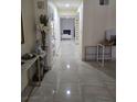 Bright hallway featuring tile floors, leading to living space with a fireplace at the end at 4342 E Russell Rd, Las Vegas, NV 89120