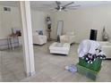 Living room features tile floors, white chairs and ottomans, large fan, and decor at 4342 E Russell Rd, Las Vegas, NV 89120