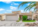 Lovely home featuring a two-car garage, manicured lawn, and mature landscaping at 738 Panhandle Dr, Henderson, NV 89014