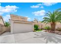 Inviting home featuring a two-car garage, manicured lawn, and mature landscaping at 738 Panhandle Dr, Henderson, NV 89014