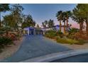 Elegant single-story home showcasing beautiful desert landscaping, lighting accents, and a circular driveway, set against a twilight sky at 7436 Oak Grove Ave, Las Vegas, NV 89117
