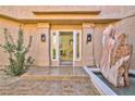 Elegant home entrance with stone fountain, modern lighting, and tiled walkway at 7711 Spanish Lake Dr, Las Vegas, NV 89113