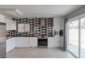 Contemporary kitchen with white cabinets, stainless steel appliances, and geometric backsplash at 8198 Palmada Dr, Las Vegas, NV 89123
