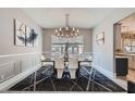 Elegant dining room with modern chandelier, wainscoting detail, and sleek chairs around a wooden table at 9611 Trattoria St, Las Vegas, NV 89178