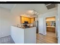 Well-lit kitchen featuring a stainless steel refrigerator and appliances with a view to the bathroom at 10245 S Maryland Pkwy # 255, Las Vegas, NV 89183
