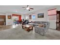 Comfortable living room featuring neutral tones, a ceiling fan, and ample natural light at 10368 Pima Crossing Ave, Las Vegas, NV 89166