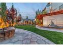 A relaxing outdoor space is captured with a stone fire pit and pergola movie screen, perfect for entertainment at 10988 Wonder Hills St, Las Vegas, NV 89141