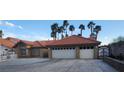 Single-story home showcasing a terra cotta roof, three car garage, long driveway, and desert landscaping at 1163 Spanish Armada Rd, Las Vegas, NV 89123