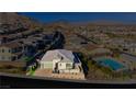An aerial view of a single-story home with desert landscaping, pool, and a paver driveway at 11700 Belorado Ave, Las Vegas, NV 89138