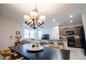 Open concept living room with a modern chandelier and lots of natural light at 1187 Kiamichi Ct, Henderson, NV 89002