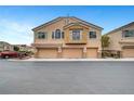 Inviting townhouse featuring three-car garage, neutral stucco exterior, and low maintenance landscaping at 1552 Wild Willey Way, Henderson, NV 89002