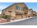Attractive townhouse showcasing a three-car garage, neutral stucco, and well-maintained landscaping at 1552 Wild Willey Way, Henderson, NV 89002