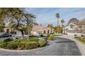 Well-maintained circular driveway, mature trees, and manicured landscaping add to this home's curb appeal at 1720 Sand Storm Ct, Henderson, NV 89074