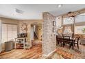 Open-concept dining room featuring wood floors, brick accents, and natural light at 1721 Derbyshire Dr, Las Vegas, NV 89117