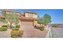Two-story home with tile roof, desert landscaping, and a brick-paver driveway at 21 Via Mantova # 3, Henderson, NV 89011
