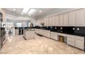 Spacious kitchen featuring granite countertops, central island, stainless steel appliances, and abundant natural light from a skylight at 2971 Fort Matanzas Ter, Henderson, NV 89052