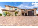 Stunning exterior with brick driveway, stone accents, a three car garage, and a private balcony at 386 Cactus River Ct, Henderson, NV 89052
