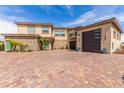 Stunning exterior with brick driveway, stone accents, a three car garage, and a private balcony at 386 Cactus River Ct, Henderson, NV 89052