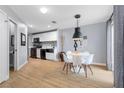 Modern dining area with stylish lighting, wood-look floors, and adjacent kitchen at 3950 S Sandhill Rd # 132, Las Vegas, NV 89121