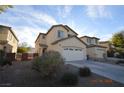Beige two-story home with a two-car garage and simple desert landscaping at 41 Rosa Rosales Ct, North Las Vegas, NV 89031