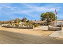 Exterior of a cozy ranch-style home with a block fence, ample parking, and mature landscaping at 4795 W Maulding Ave, Las Vegas, NV 89139