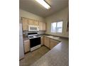 Well-lit kitchen equipped with a gas range, microwave, and double sink at 5650 E Sahara Ave # 2041, Las Vegas, NV 89142