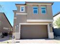 Two-story home features neutral paint, stone accents, a two-car garage, and manicured landscaping at 6507 Dove Point Pl, Las Vegas, NV 89130