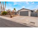 Inviting exterior highlighting a neutral color scheme, low-maintenance desert landscaping, and a two-car garage at 6594 Casa Linda Dr, Las Vegas, NV 89103