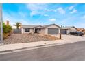 Street view showcasing the house with desert landscaping, including drought-resistant rocks, and a two-car garage at 6594 Casa Linda Dr, Las Vegas, NV 89103