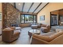 Spacious living room with stone fireplace, beamed ceilings, and large windows at 6998 Alamitos Cir, Las Vegas, NV 89120