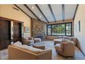 Comfortable living room with stone fireplace, beamed ceilings, and built-in bookcase at 6998 Alamitos Cir, Las Vegas, NV 89120