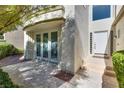 Home exterior with a doorway, light colored stucco, and well maintained yard at 8200 Horseshoe Bend Ln, Las Vegas, NV 89113