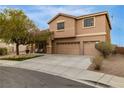 Two-story tan stucco home with three-car garage, landscaped yard, and covered porch at 827 Happy Sparrow Ave, Henderson, NV 89052