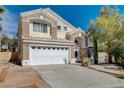Charming two-story home featuring a large front yard, two-car garage, and stone and stucco facade at 8988 Dusseldorf Way, Las Vegas, NV 89147